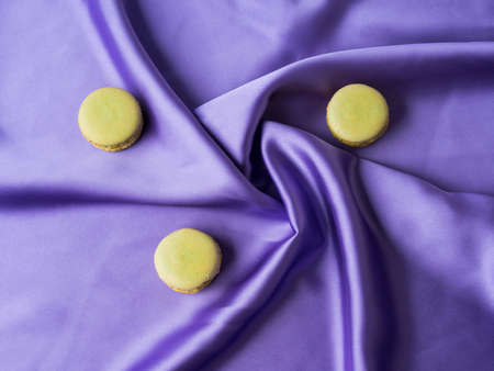 Pastel green french macaroons on purple silk fabric backgroundの写真素材