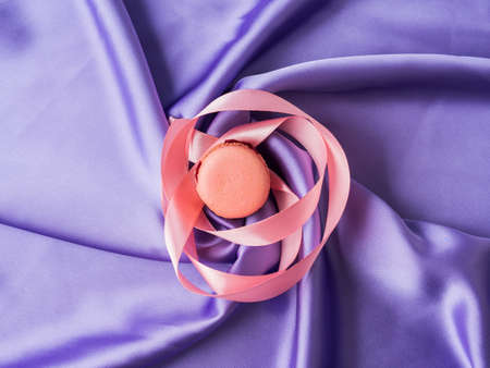 Pastel pink french macaroons on purple silk fabric backgroundの写真素材