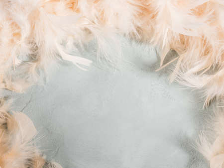 Trendy yellow feather frame on turquoise background