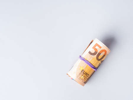 Euro 50 value banknotes roll with rubber on gray background