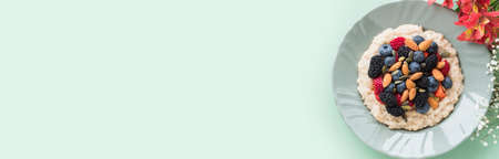 Delicious breakfast oat porridge on plant milk with nuts and berries on marble tableの写真素材