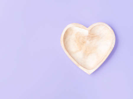 Empty heart shaped wooden dish on purple backgroundの写真素材