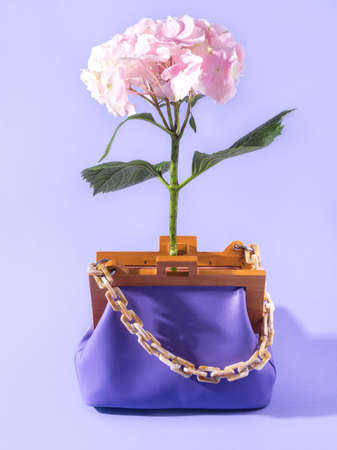 Purple leather fashion lady handbag with pink flower, summer accessory conceptの写真素材