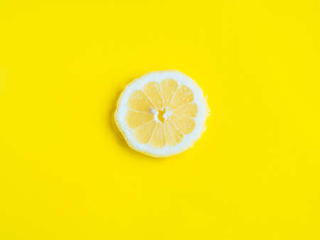 Intense yellow lemon citrus slice in water, texture summer backgroundの写真素材