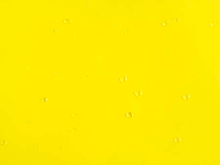 Yellow bold color background with water drops on the surfaceの写真素材