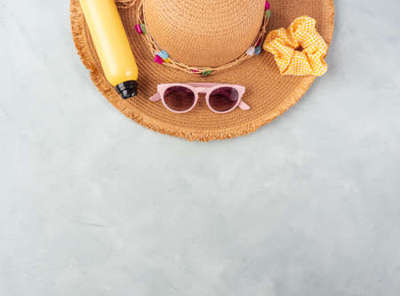 Summer lady straw hat, yellow sun protection spray and sunglasses