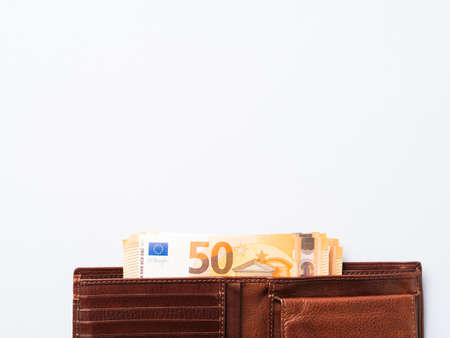 Euro money currency 50 value banknotes in expensive leather wallet on blue background