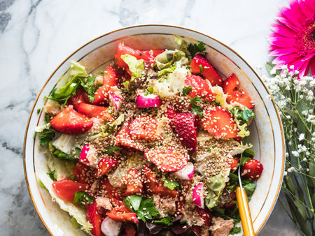 Fresh summer healthy fiber protein vitamin salad in bowl with strawberries, lettuce, tuna, tomatoesの写真素材