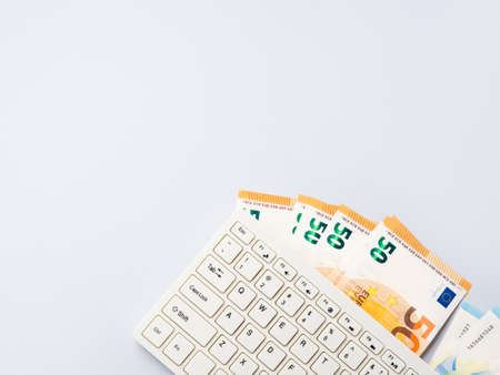 Euro money banknotes under keyboard, online banking, sale of digital info products concept