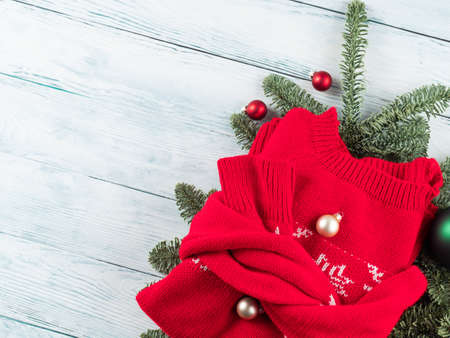 Traditional red ugly christmas new year winter sweater with green ornament on white wooden tableの写真素材