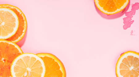 Summer vibe orange citrus slice fruit texture background on pastel pink with wet spotsの写真素材
