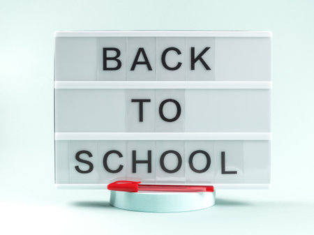 White lightbox with back to school text on light blue background with red pen on podiumの写真素材