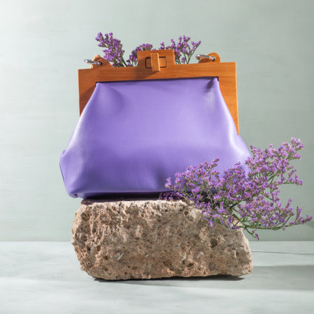 Natural rough gray stone podium with purple female handbag flowersの写真素材