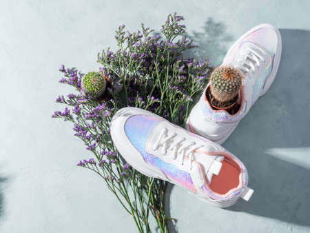 White sneakers with sequins and purple flowers on turquoise backgroundの写真素材
