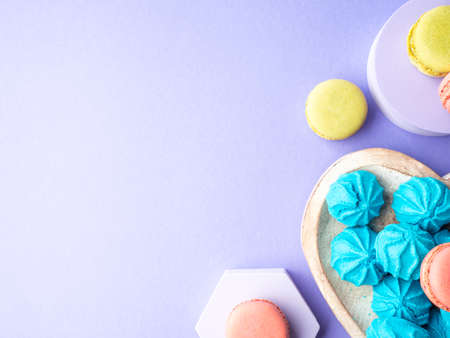 Heart shaped wooden dish with blue sweet meringues and macaroonsの写真素材