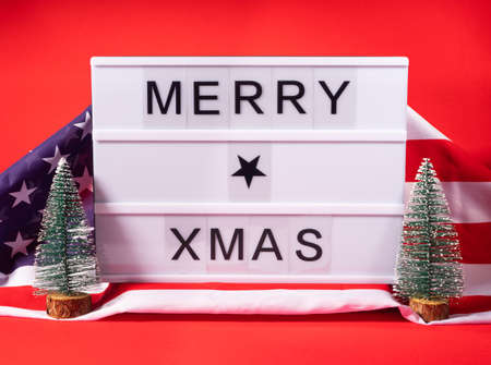 Christmas greetings lightbox Merry xmas on red with american flagの写真素材