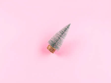 Small toy christmas tree on pink background, winter holiday symbolの写真素材
