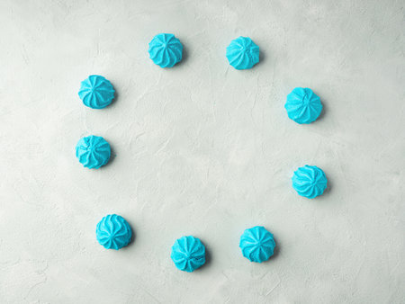 Blue meringue frame on gray stone background, flat layの写真素材
