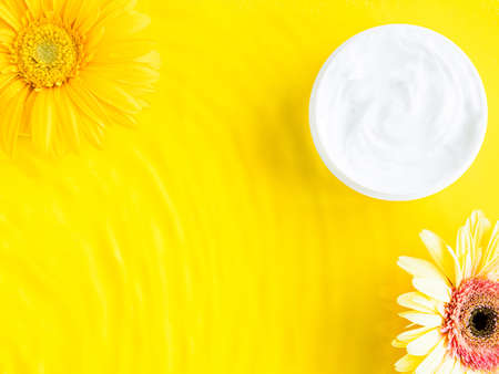 Generic white cream jar on yellow background with water ripplesの写真素材