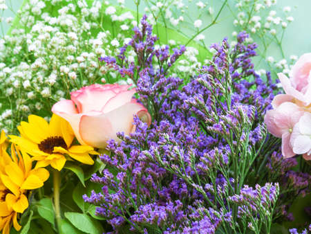 Colorful beautiful spring bouquet closeup. Roses, sunflower, purple flowersの写真素材