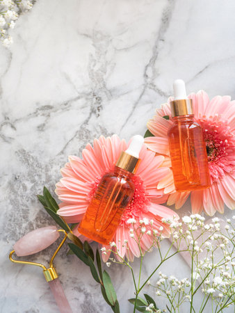 Cosmetic serum bottle and pink quartz face roller guashaの写真素材