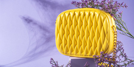 Yellow fashion lady handbag with purple flowers on monochrome backgroundの写真素材