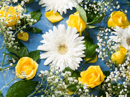 Floral background with yellow and white flowers on blueの写真素材