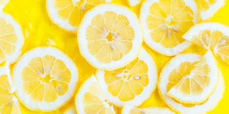 Lemon citrus slices in water, bold yellow texture summer backgroundの写真素材