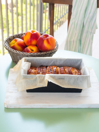 Vegan peach cake in baking mould on green table outdoorsの写真素材