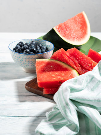 Seedless watermelon and blueberries on wooden background, summer fruitの写真素材