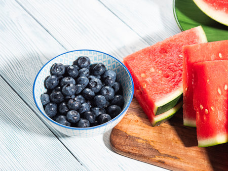 Seedless watermelon and blueberries on wooden background, summer fruitの写真素材