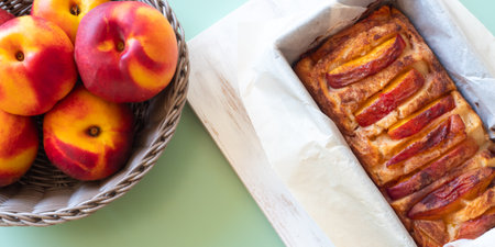 Vegan peach cake in baking mould on green table outdoorsの写真素材
