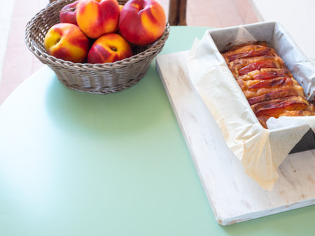 Vegan peach cake in baking mould on green table outdoorsの写真素材