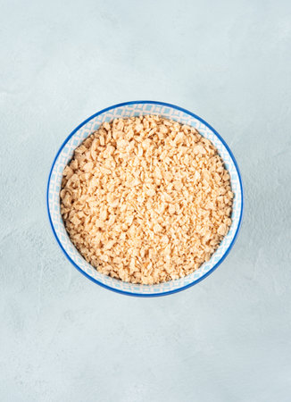 Soya protein textured granules in bowl on blue backgroundの写真素材