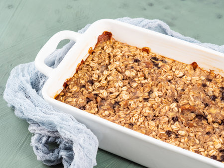 Oatmeal porridge granola cake in white baking tray on greenの写真素材