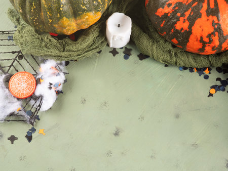 Halloween green frame background flatlay with colorful pumpkins and confettiの写真素材