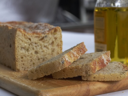slide olive bread loaf on wooded chopping boardの写真素材