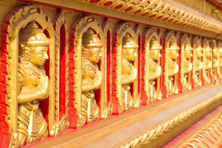 Row of Buddha images on the wall.の写真素材