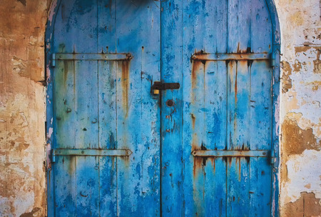 Old blue wooden rustic painted door in the countryside with metal hinges with rustの写真素材