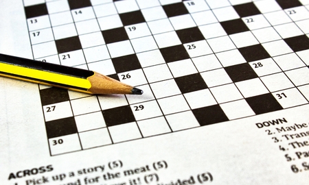 Closeup of crossword puzzle from a newspaper with a black and yellow lead pencilの写真素材