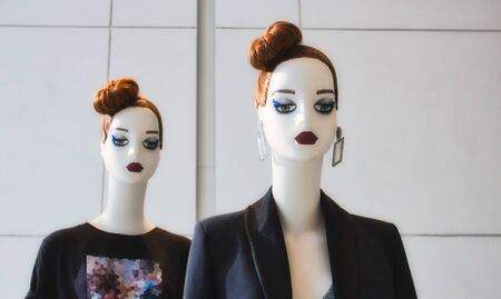 Two identical white fashion mannequins displaying modern clothesの写真素材