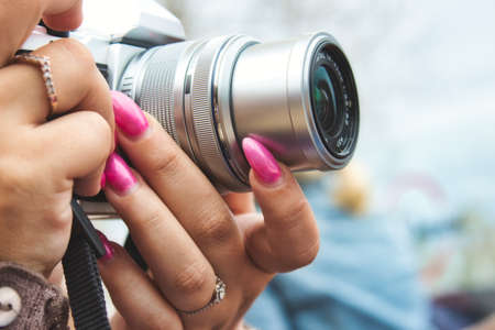 Close-up of a digital camera being used by a woman with painted fingernailsの写真素材