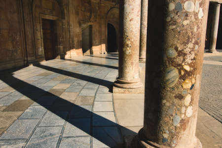 Columns casting shadows in the Charles V Palace at the Alhambra in Granada, Spainの写真素材