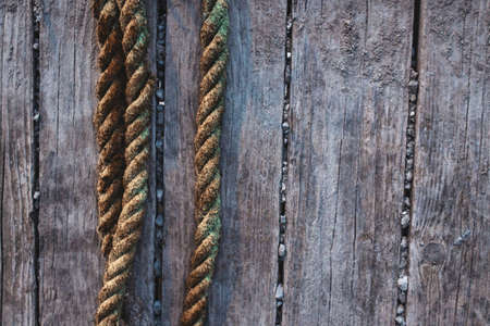 Yellow weathered ropes against rustic wooden boardsの写真素材