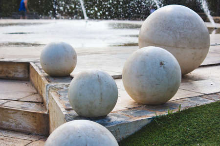 Giant white marble spheres on a modern design fountain in a public parkの写真素材
