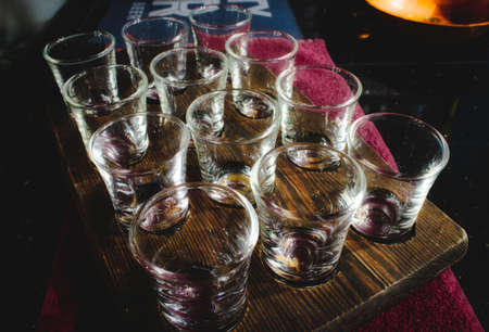 Shot glasses set in a wooden tray in a traditional English pubの写真素材