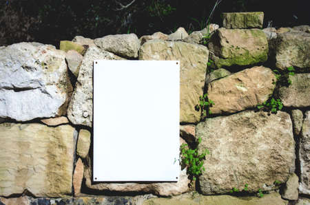 Blank white sign on a rural stone wall in the coutrysideの写真素材