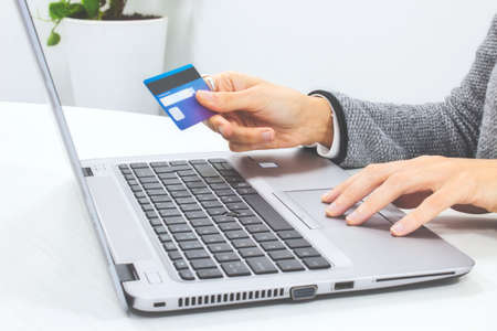 Woman making an online payment with her credit card and laptop computer