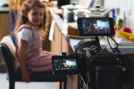 Video camera filming a movie scene with a young girl in the backgroundの写真素材