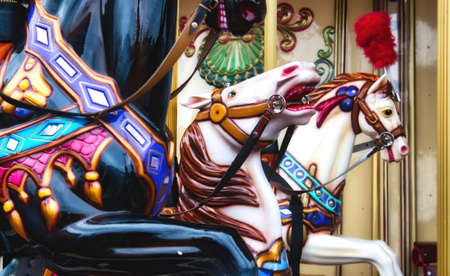 Close-up of colorful horses on a traditional vintage merry-go-round ride at a funfairの写真素材